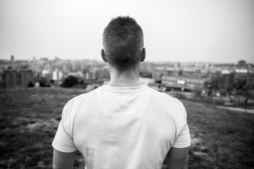 Silueta de espaldas que representa a una persona mirando a lo lejos, con la ciudad de fondo y reflexionando sobre como se ha vaciado y empieza a evolucionar desde el despertar